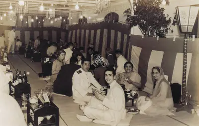 Unknown (Photographer). A Japanese dinner aboard the SS Asama Maru, America bound. A Purser with Bapsy, her friend Piroja and Jehangir, 1939 | Contemporary Photograph