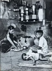 Bacha, Major R. A. (Photographer). A Mill Labourer's Wife Prepares a Meal with Her Children by Her Side, n.d. | Contemporary Photograph