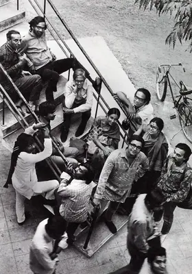 Bhatt, Jyoti  (Photographer). Students and teachers at the Faculty  of Fine Arts, MS University of Baroda. The group includes Khakhar (seated at centre), Manu Desai, Gulammohammed Sheikh, Nilima Sheikh, Ushakant Mehta, Jeram Patel and Mrinalini Mukherjee. Photographic Still, 1970 | Contemporary Photograph, Bhupen Khakhar, 1998 | Photography | 00149862