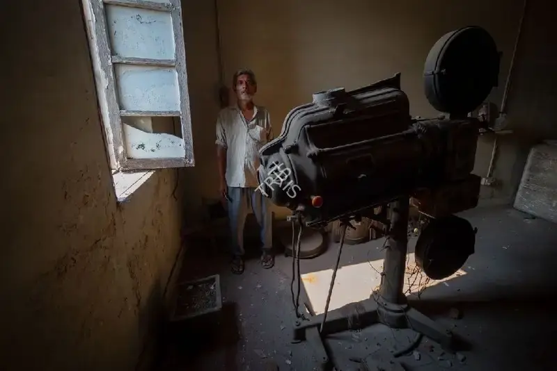 Hemant Chaturvedi (Photographer), The projectionist of Hind Talkies, Bareilly, Uttar Pradesh standing alongside the projection apparatus, 2024, Contemporary Photograph