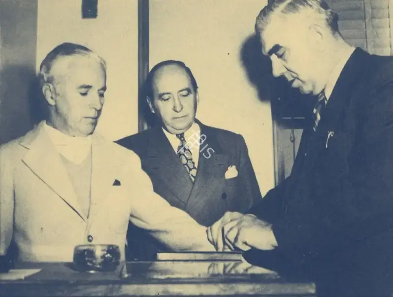 Unknown (Photographer). Charlie Chaplin - Chaplin's fingerprints being taken at a police station in the wake of the controversy regarding his communist ties | Photographic Still, My Life in Pictures, 1985 | CinemaEducation | 00440372