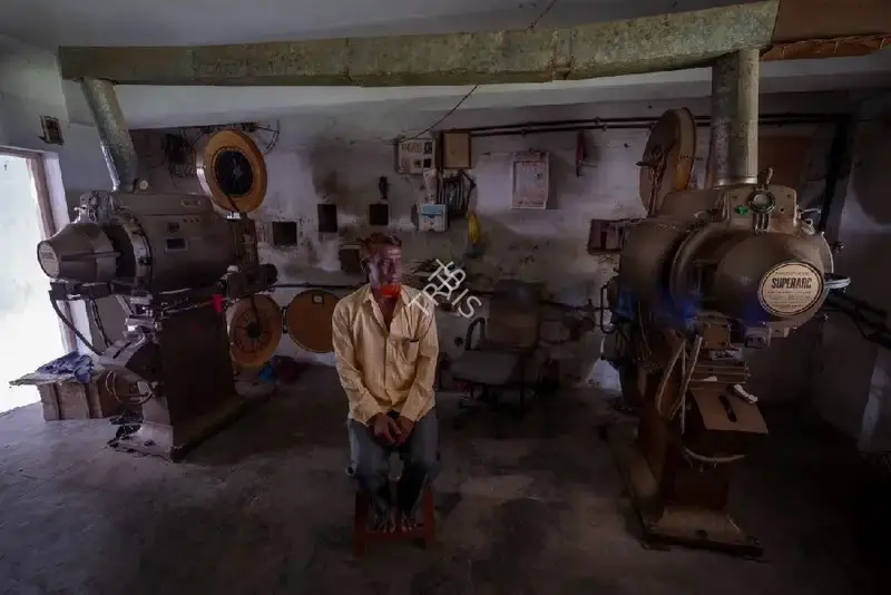 Hemant Chaturvedi (Photographer), The projectionist of Feroze Talkies, Parbhani, Maharashtra standing alongside the projection apparatus, 2024, Contemporary Photograph