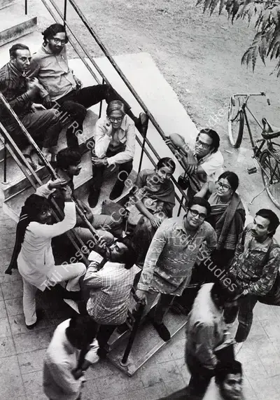 Bhatt, Jyoti  (Photographer). Students and teachers at the Faculty  of Fine Arts, MS University of Baroda. The group includes Khakhar (seated at centre), Manu Desai, Gulammohammed Sheikh, Nilima Sheikh, Ushakant Mehta, Jeram Patel and Mrinalini Mukherjee. Photographic Still, 1970 | Contemporary Photograph, Bhupen Khakhar, 1998 | Photography | 00149862